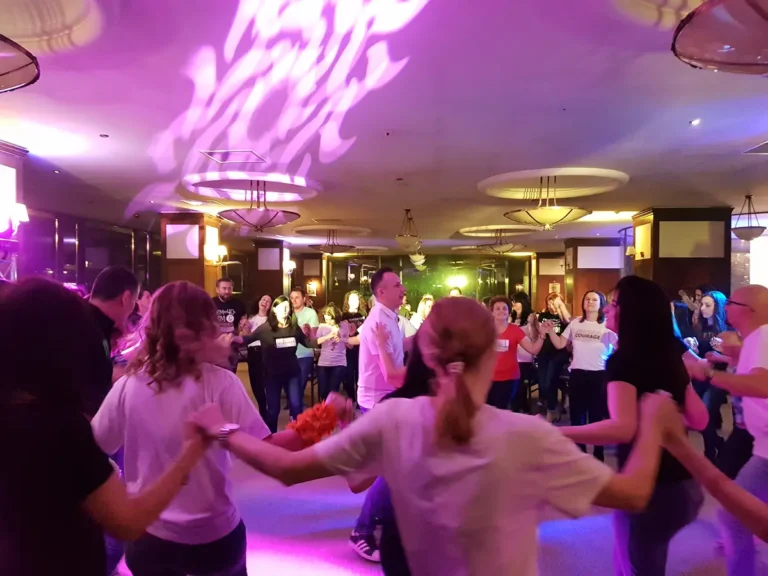 Hora invitaților la o petrecere privată, sub lumini colorate