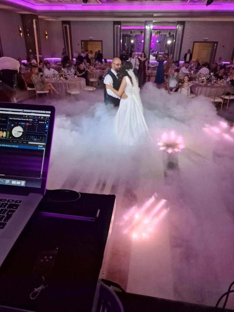 Mirii dansând în fum greu, văzuți de la pupitrul DJ